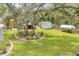 The backyard features a manicured lawn, mature trees, and a charming shed, creating a peaceful retreat at 2163 County Road 243F, Wildwood, FL 34785