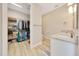Bathroom with dual sinks, white cabinets, and adjacent walk-in closet at 2163 County Road 243F, Wildwood, FL 34785