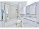 Bathroom featuring a tub and shower combo, single sink vanity with ample lighting and storage space at 2163 County Road 243F, Wildwood, FL 34785