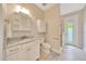Bright bathroom features white cabinets, a sink with marble countertop, toilet and a shower stall with a glass door at 2163 County Road 243F, Wildwood, FL 34785