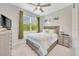 Cozy bedroom with a bed, TV, dresser, ceiling fan, and a window with plenty of natural light at 2163 County Road 243F, Wildwood, FL 34785
