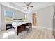 Bedroom with wood-look floors, ceiling fan, en suite bath, and natural light at 2163 County Road 243F, Wildwood, FL 34785