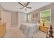 Comfortable bedroom with a ceiling fan, closet, carpet flooring and natural light from large windows at 2163 County Road 243F, Wildwood, FL 34785