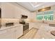 Bright kitchen featuring white cabinets, granite countertops, and stainless steel appliances at 2163 County Road 243F, Wildwood, FL 34785