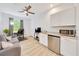 The living room features a kitchenette, ceiling fan, and is illuminated by a window bringing in natural light at 2163 County Road 243F, Wildwood, FL 34785