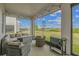 Relaxing screened-in back porch featuring comfortable seating and a beautiful view of the yard at 2350 Gold Dust Dr, Clermont, FL 34715