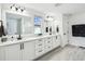 Modern bathroom featuring dual vanities with quartz countertops, mirrors, and a glass shower at 2350 Gold Dust Dr, Clermont, FL 34715