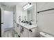 Bright bathroom featuring double sinks, white cabinets, and black fixtures at 2350 Gold Dust Dr, Clermont, FL 34715