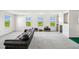 Bright bonus room with multiple windows, black leather couch, and custom climbing wall at 2350 Gold Dust Dr, Clermont, FL 34715