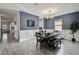 An open dining room boasts modern lighting, wainscoting and wood-look flooring leading to the kitchen at 2350 Gold Dust Dr, Clermont, FL 34715
