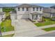 Exterior elevation of a two story home with a large driveway and well maintained lawn and landscaping in the front yard at 2350 Gold Dust Dr, Clermont, FL 34715