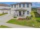 Charming two-story home boasting a covered front porch, a three car garage, and well-manicured landscaping at 2350 Gold Dust Dr, Clermont, FL 34715