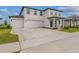 Charming two-story home boasting a covered front porch, a three car garage, and well-manicured landscaping at 2350 Gold Dust Dr, Clermont, FL 34715