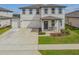 Charming two-story home boasting a covered front porch, a three car garage, and well-manicured landscaping at 2350 Gold Dust Dr, Clermont, FL 34715