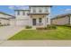 Charming two-story home boasting a covered front porch, a three car garage, and well-manicured landscaping at 2350 Gold Dust Dr, Clermont, FL 34715