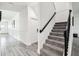 Bright hallway with tiled floors leading to a carpeted staircase with dark wood railing at 2350 Gold Dust Dr, Clermont, FL 34715