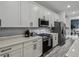 Updated kitchen featuring white cabinets, stainless steel appliances, gray backsplash and wood-look floors at 2350 Gold Dust Dr, Clermont, FL 34715