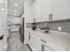 Bright kitchen features white cabinets, gray backsplash, white countertops and wood-look tile flooring at 2350 Gold Dust Dr, Clermont, FL 34715