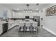 The open kitchen features white cabinets, gray backsplash, stainless steel appliances, and an island with seating at 2350 Gold Dust Dr, Clermont, FL 34715