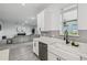 Modern kitchen with a white farmhouse sink, gray backsplash, and stainless steel dishwasher at 2350 Gold Dust Dr, Clermont, FL 34715