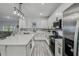 Bright kitchen features white cabinets, stainless appliances, gray backsplash and wood-look flooring at 2350 Gold Dust Dr, Clermont, FL 34715