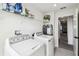 Bright laundry room with modern washer and dryer, wire shelving, and easy access to the hallway at 2350 Gold Dust Dr, Clermont, FL 34715