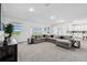 Open-concept living room with a large sectional couch and scenic views through the windows at 2350 Gold Dust Dr, Clermont, FL 34715