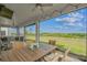 Covered outdoor patio with ceiling fan and string lights showcasing beautiful view of the green landscape and blue sky at 2350 Gold Dust Dr, Clermont, FL 34715