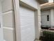 Attached garage with white paneled door and light-colored trim at 2450 Sweetwater Country Club Dr, Apopka, FL 32712