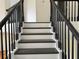 Staircase with black railings and dark wood treads provides a stylish transition at 2450 Sweetwater Country Club Dr, Apopka, FL 32712