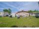 Spacious backyard with lush green grass, showcasing the home's exterior, grill, shed, and decorative dog art at 2475 Karen Dr, Mount Dora, FL 32757