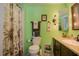 Cozy green bathroom featuring a shower-tub, sink vanity, and decorative palm tree accents at 2475 Karen Dr, Mount Dora, FL 32757