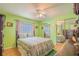Bright bedroom with green walls, mirrored closet, ceiling fan, and natural light at 2475 Karen Dr, Mount Dora, FL 32757