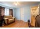 Blue bedroom includes ceiling fan, wood floors, and access to a hallway and a closet at 2475 Karen Dr, Mount Dora, FL 32757