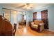 Comfortable blue bedroom with hardwood floors, an armchair, and a mirrored closet at 2475 Karen Dr, Mount Dora, FL 32757