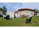 Exterior view of a well-maintained backyard with lush greenery, a grill, a shed, and some dog-shaped art at 2475 Karen Dr, Mount Dora, FL 32757