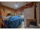 A cluttered garage with wood paneling, a tiled floor, and an assortment of furniture and exercise equipment at 2475 Karen Dr, Mount Dora, FL 32757