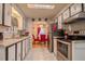 Well-lit kitchen features stainless steel appliances and white cabinets with access to dining room at 2475 Karen Dr, Mount Dora, FL 32757