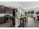 Modern kitchen with stainless steel appliances, a center island with bar stools, and sliding door access to the backyard at 2532 Autumn Stream Dr, Leesburg, FL 34748