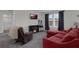 Cozy living room features a red sofa, electric fireplace and large windows at 2532 Autumn Stream Dr, Leesburg, FL 34748