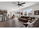 Open-concept living area with a comfortable leather sofa, a ceiling fan, and great natural light at 2532 Autumn Stream Dr, Leesburg, FL 34748