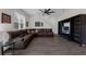 Spacious living room featuring a large sofa, a modern ceiling fan, and a sleek entertainment center at 2532 Autumn Stream Dr, Leesburg, FL 34748