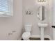 Powder room with a pedestal sink, toilet, and decorative wall art at 2532 Autumn Stream Dr, Leesburg, FL 34748