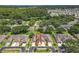 An aerial view shows the neighborhood's layout, lush greenery, homes, and serene pond at 264 Juniper Way, Tavares, FL 32778