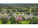 An aerial view shows the neighborhood's layout, lush greenery, homes, and serene pond at 264 Juniper Way, Tavares, FL 32778