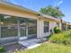 Rear exterior of home featuring a screened lanai and well-maintained landscaping at 264 Juniper Way, Tavares, FL 32778