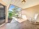 Charming outdoor patio with rocking chair, adjacent to attached garage at 264 Juniper Way, Tavares, FL 32778