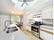 Bright kitchen with stainless steel appliances, island, and adjacent dining area at 264 Juniper Way, Tavares, FL 32778
