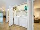 Convenient laundry closet with a washer and dryer located between the bathroom and den at 264 Juniper Way, Tavares, FL 32778