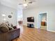 The bright living room with hardwood floors connects seamlessly with other living areas at 264 Juniper Way, Tavares, FL 32778